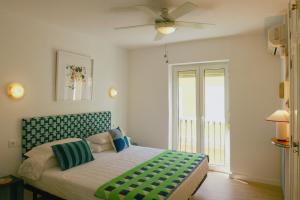 a bedroom with a bed with a ceiling fan at Caleta Club - 4 BDR Rooftop Villa in Cádiz
