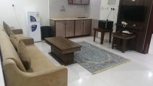 una sala de estar con un sofá y una mesa en شقق ظل النخيل للشقق المخدومة, en Hotat bani tamim