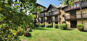 an apartment building with a yard in front of it at Résidence Cretes - Studio + alcôve centre village MAE-0224 in Le Monêtier-les-Bains