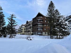 a building in the snow with trees in front at Résidence Grand Serre Che A - STUDIO COIN MONTAGNE 4 PERS MAE-4894 in La Salle Les Alpes