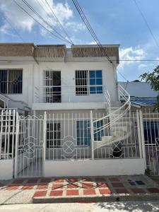 a white house with a gate in front of it at Hermoso apto piso 2 barrio san jose in Barranquilla