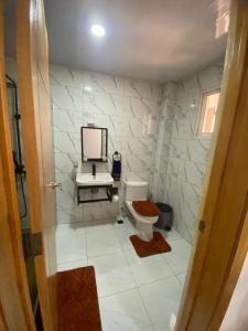 a bathroom with a toilet and a sink and a mirror at Nido de Paz Amplio, Moderno y Acogedor in Bonao +8 photos