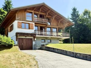 une grande maison avec un toit en bois et un garage dans l'établissement Chalet Cristal - Chalet de charme avec sauna et superbe vue sur le MOnt Charvin et les Aravis MAE-1154, à Crest-Voland