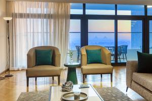 开罗Cairo Homes Maadi Nile View Family的有两把椅子和一张桌子的客厅