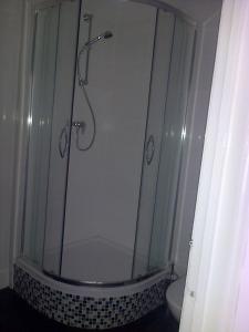 a bathroom with a shower with a glass door at Andorinho Sea View Apartment in Margate