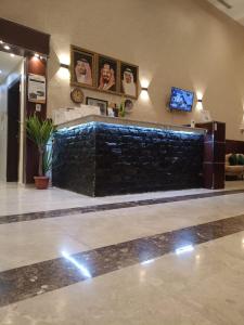a lobby with a large stone wall in a building at اختيار السائح للشقق المخدومة in Jazan