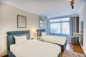 开罗Cairo Homes Maadi Nile View Family的有两张床和一扇窗户的酒店房间