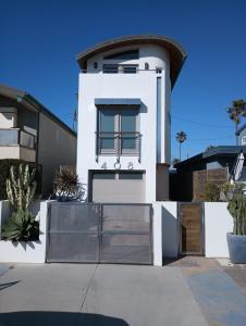 a white house with a gate in front of it at Dragan's Cove in Oxnard