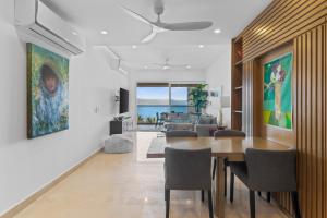 een eetkamer en woonkamer met een tafel en stoelen bij Magnificent condo with ocean view in Puerto Vallarta