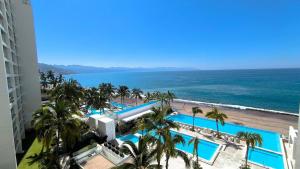 een luchtzicht op een resort met palmbomen en de oceaan bij Magnificent condo with ocean view in Puerto Vallarta
