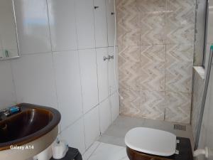 a bathroom with a toilet and a sink at Pousada do caminho in Águas da Prata +14 photos