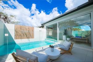 a house with a swimming pool and a patio at Coastal Haven Retreat - Luxe Airlie Beach Holiday Home in Airlie Beach