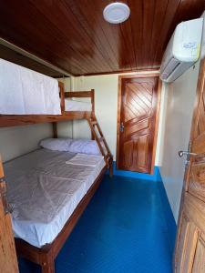 a small bedroom with two bunk beds and a door at Aluguel embarcação cop 30 com 21 suítes in Belém