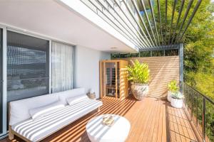 a patio with a couch and a table on a deck at Coastal Haven Retreat - Luxe Airlie Beach Holiday Home in Airlie Beach +12 photos