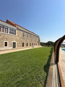 an external view of a building with a green lawn at Palacium Charming Suites in Figueiró dos Vinhos