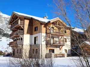ein Gebäude mit Balkon auf der Seite im Schnee in der Unterkunft Résidence Le Criterium - Résidence Le Critérium 3 Chalet D Appartement 3 MAE-4581 in Lanslebourg-Mont-Cenis