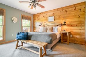 a bedroom with a bed and a wooden wall at Sleeps 24 2 Homes Hot Tub Sauna Movie Theater Firepit Pool Tennis Courts in Gatlinburg +188 photos
