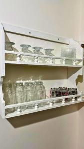 a shelf filled with glasses and other glass items at Cozy Apartment Near Rabat & Beach in Temara