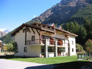 a large building with a mountain in the background at Résidence Le Soliet 2 - 2 Pièces pour 6 Personnes MAE-7771 in Bessans
