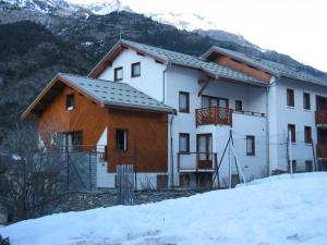 a house in the snow with mountains in the background at Résidence Le Saint Genix - 2 Pièces pour 4 Personnes MAE-0383 in Val Cenis