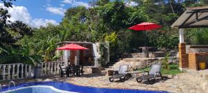 a patio with chairs and umbrellas next to a pool at Cabaña Orquidea Campestre in Fusagasuga +13 photos