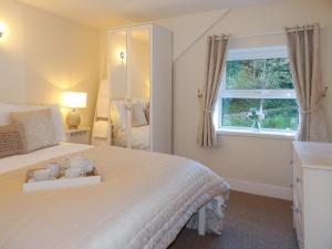 a bedroom with a white bed with a window at The Loft, Lynmouth - Uk41697 in Lynmouth