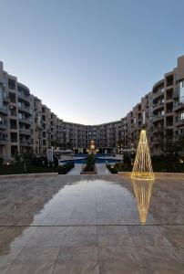 ein großes Apartmenthaus mit einer Skulptur davor in der Unterkunft Princess Resort Hurghada in Hurghada