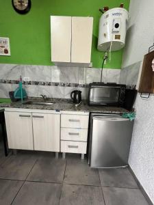 una cocina con fregadero y microondas en COMPLEJO AyH, en Malagueño