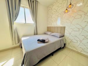 una camera da letto con un letto con una borsa sopra di Apê ideal para Você, com Academia e Piscina a Cuiabá Altre 32 foto