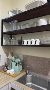 a kitchen with a sink and a shelf with dishes at Casa Tranquila Airpot Transit Stay in Dar es Salaam +25 photos