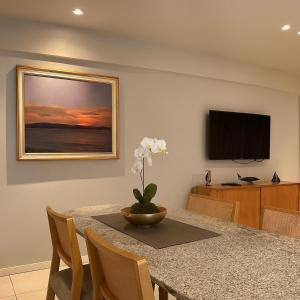 a dining room with a table with a vase of flowers at 535 Flat Residência in Salvador +5 photos