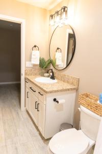 a bathroom with a sink and a toilet and a mirror at Sequoia Oasis near Downtown Exeter in Exeter