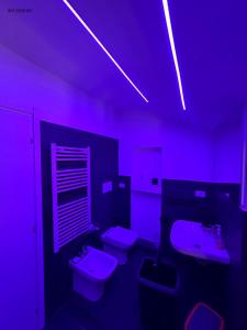a purple bathroom with two toilets and a sink at Silver Apartment in Agrate Brianza