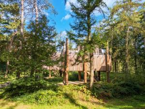 een boomhut met een terras in het bos bij Haven with Sauna & Pool in Antoing