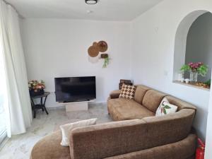 a living room with a couch and a flat screen tv at villa Loya in Ortaca