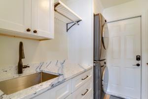 a kitchen with white cabinets and a stainless steel refrigerator at Riverfront Ruskin Home with Boat Dock, 1 Mi to Beach in Ruskin +27 photos