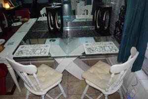 a glass counter with two white chairs at a table at Drip Star Life Hostel Miami 3 in Parkway Regional Medical Center Heliport