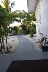 a walkway next to a building with trees and plants at Drip Star Life Hostel Miami 3 in Parkway Regional Medical Center Heliport