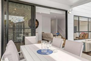 a dining room with a white table and chairs at Townhouse in Marks Point in Marks Point