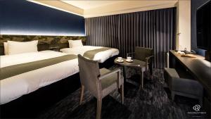 a hotel room with two beds and a desk at Daiwa Roynet Hotel Kyoto Ekimae PREMIER in Kyoto