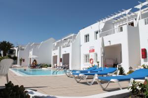 una piscina con tumbonas y un hotel en Cactus en Puerto del Carmen
