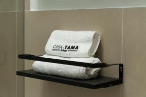 a stack of towels on a shelf in a bathroom at Hotel Casa Tama in Salento
