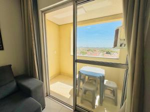 una camera con finestra, sedia e tavolo di Apê ideal para Você, com Academia e Piscina a Cuiabá