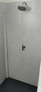 eine weiße Wand mit einer Dusche mit Abfluss in der Unterkunft Trawangan Oasis in Gili Trawangan