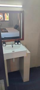 ein Badezimmer mit Waschbecken und einem Bett in einem Spiegel in der Unterkunft Trawangan Oasis in Gili Trawangan