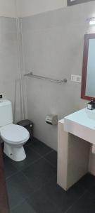 ein Badezimmer mit weißer Toilette und Waschbecken in der Unterkunft Trawangan Oasis in Gili Trawangan