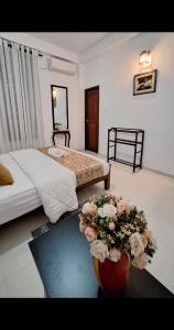 a bedroom with two beds and flowers on the floor at Rose Gold Kandy in Kandy