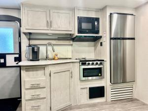 a kitchen with white cabinets and stainless steel appliances at Family Friendly Camping in Crystal River in Crystal River