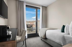 a hotel room with a bed and a balcony at Leonardo Hotel Vienna City West in Vienna