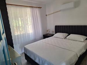 a bedroom with a bed with white sheets and a window at villa Loya in Ortaca +19 photos